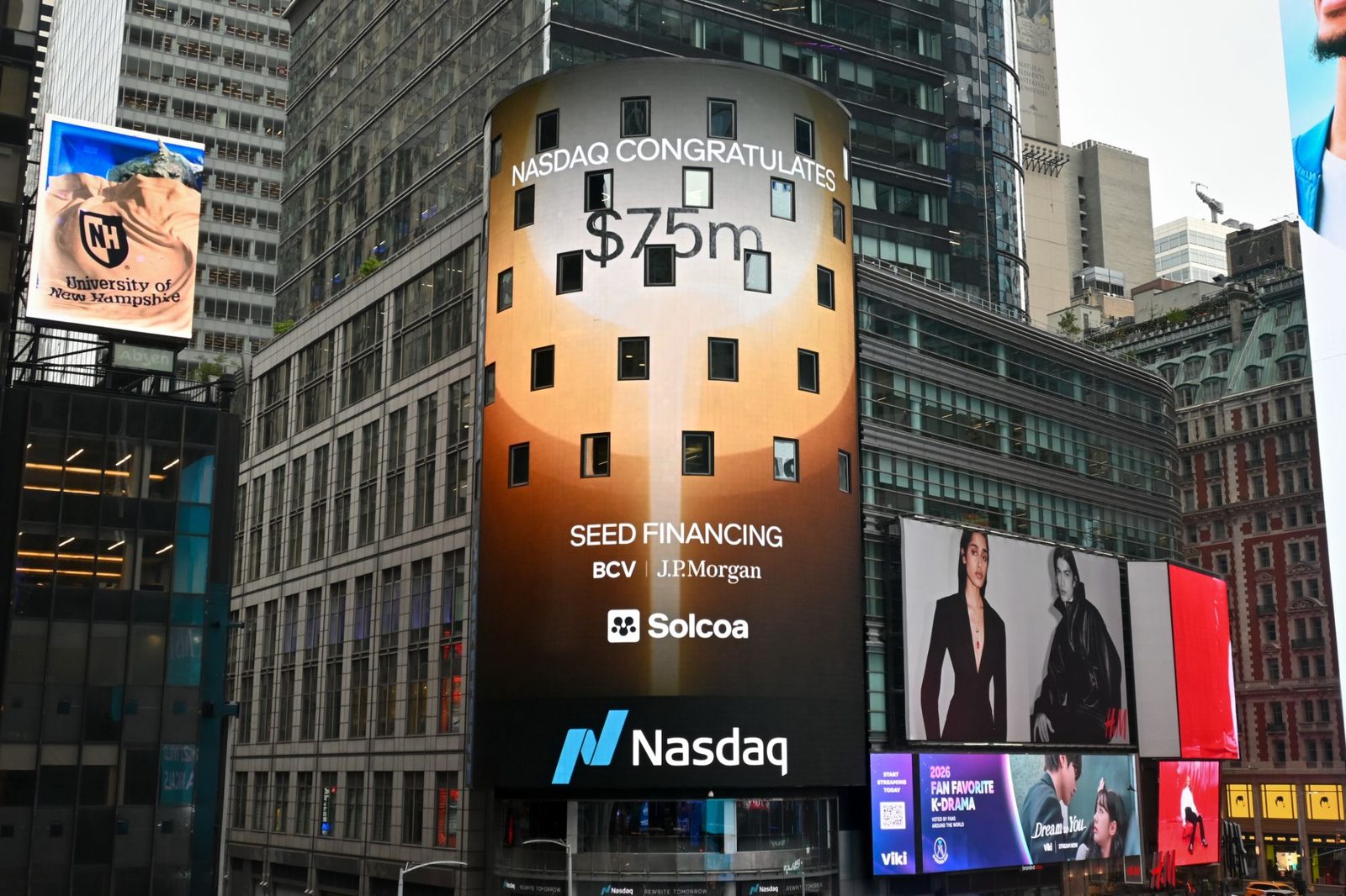 The Nasdaq tower in Times Square reading: Nasdaq congratulates $75m seed financing, BCV, J.P. Morgan, Solcoa